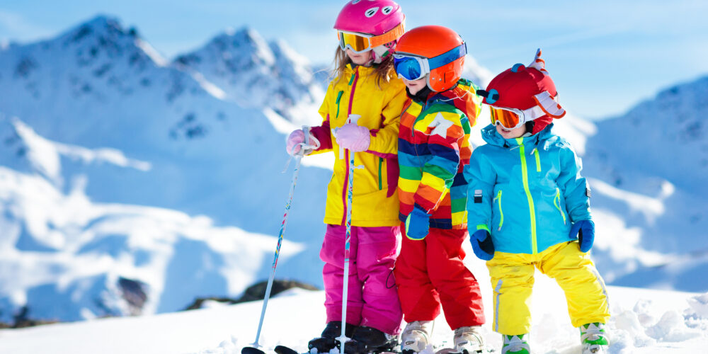 Children in bright colored clothing on a ski slope
