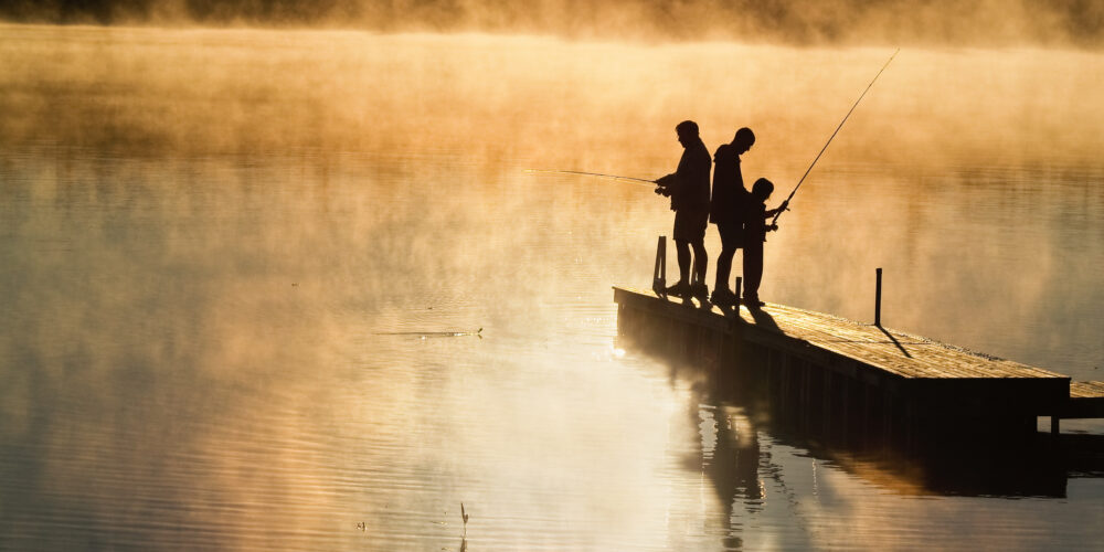 Dad with his Dad and Son fishing on a pier at dawn